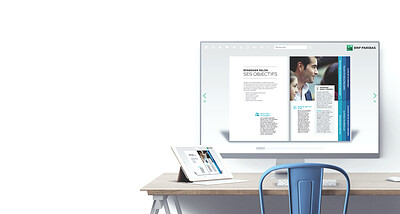 Un Fluidbook BNP Paribas affiché sur un écran d'ordinateur, une tablette posée à côté sur le bureau